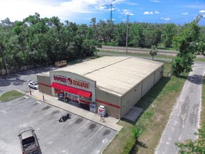 Aerial view of a long white commercial storage facility with multiple units and paved driveways in a suburban setting.
