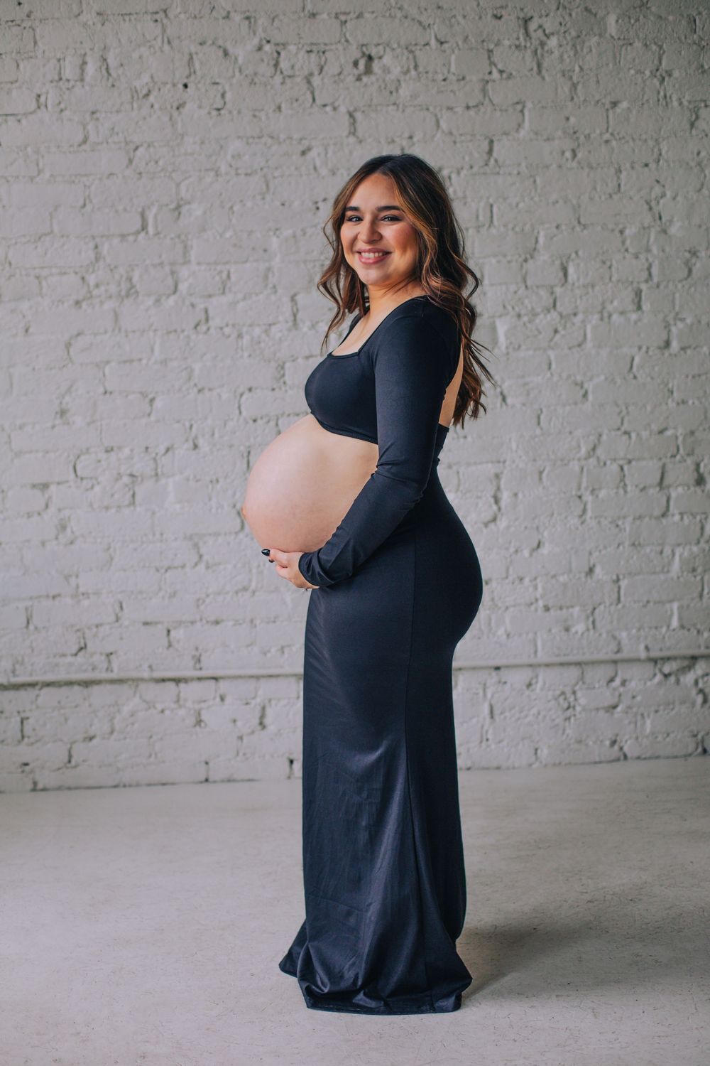 Maternity photos against white brick wall showing pregnancy progression. Spokane Liberty Lake Photographer Maternity Photographer
