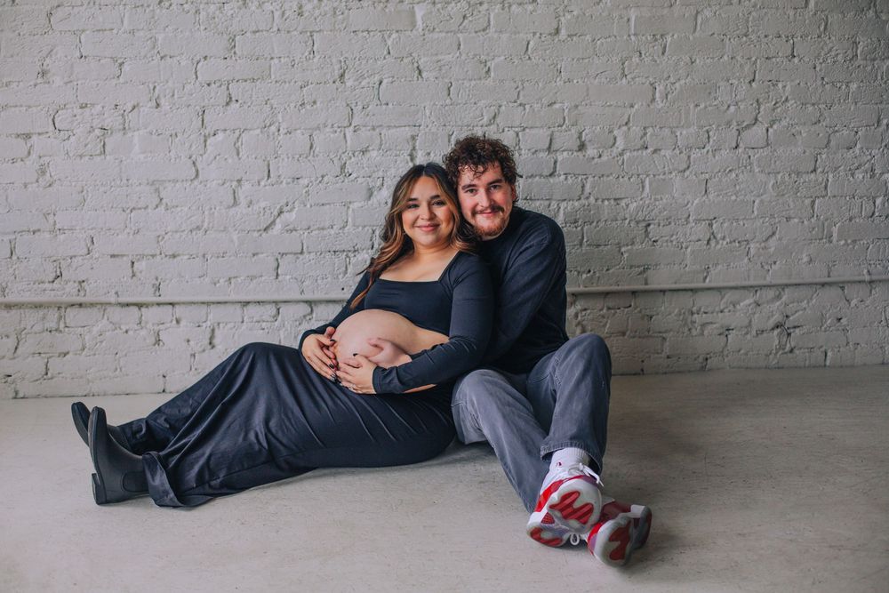 Indoor maternity session with white brick wall backdrop. Spokane Liberty Lake Photographer Maternity Photographer