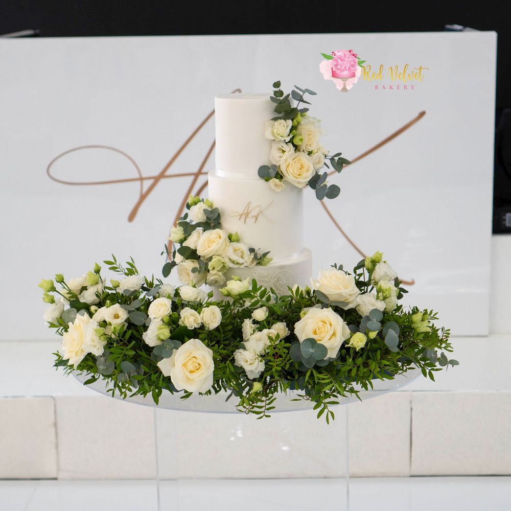 3 tier double barrel white wedding cake with fresh flowers