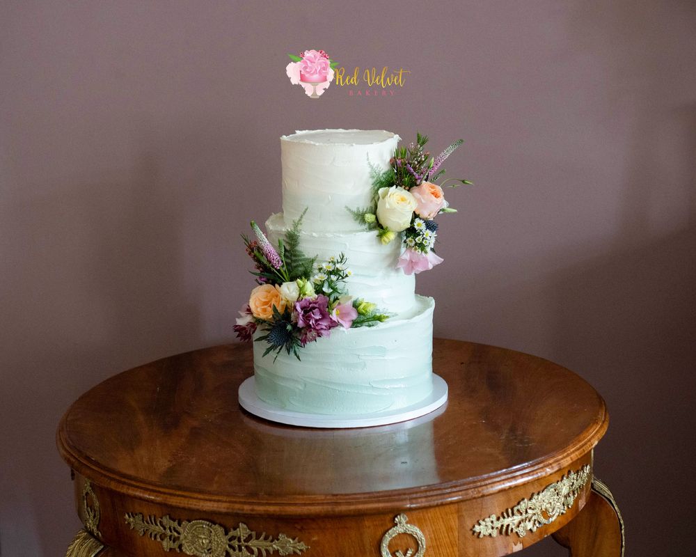 3 tier green buttercream wedding cake with fresh flowers