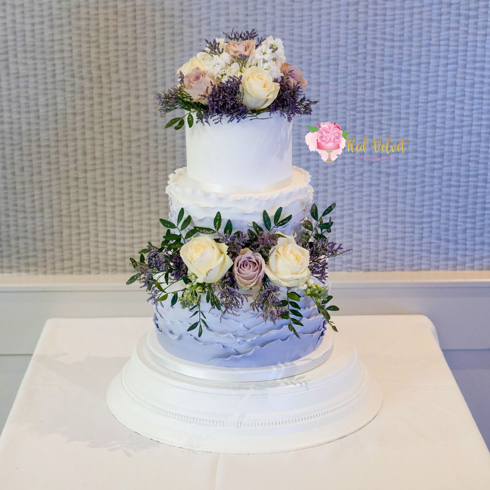 3 tier purple and white ombre finished fondant wedding cake finished with fresh roses and green foliage