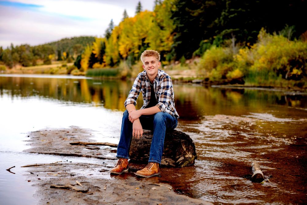 A series of outdoor photos showing someone sitting on rocks by a scenic lake with autumn trees in the background. Senior Pueblo Photographer