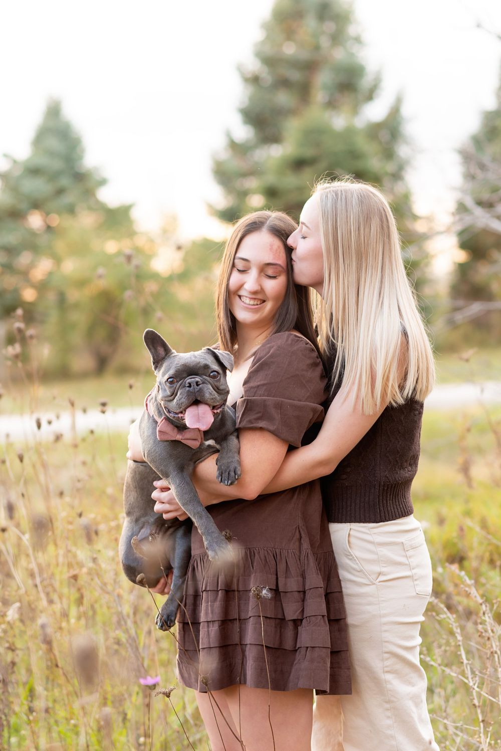 French bulldog being held and kissed by owners in autumn field setting at  AT KOMOKA PROVINCIAL PARK Pond.