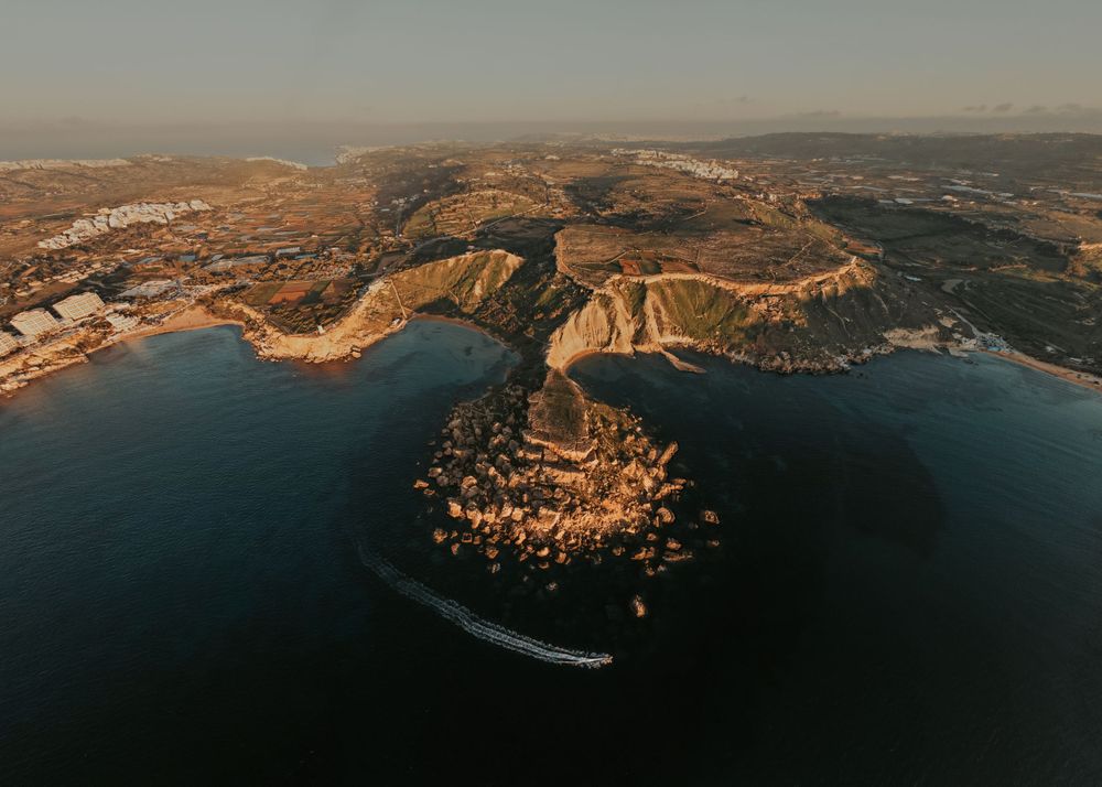 Panoramic coastal landscape at sunset showing dramatic cliffs and ocean views.