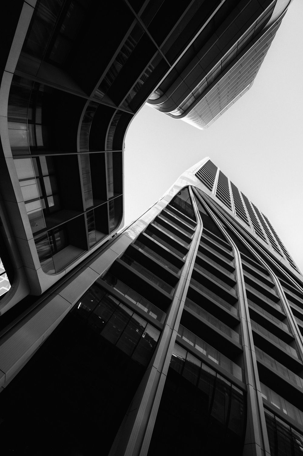 Low angle black and white architectural shot of modern building with geometric lines and angles.