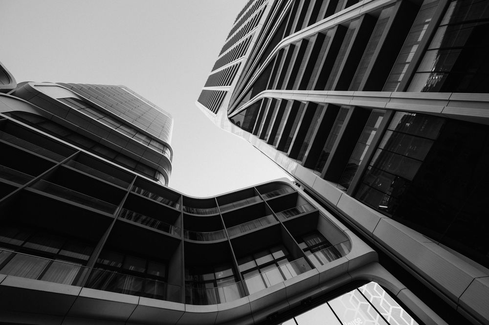 Abstract architectural patterns in black and white showing angular building details against bright sky.