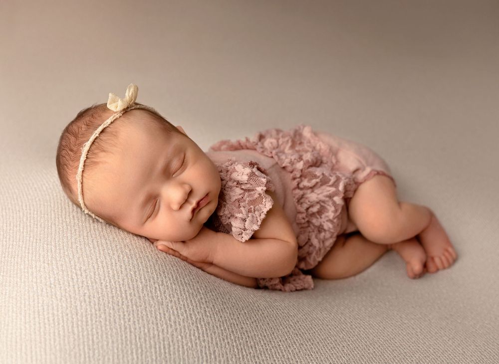 Newborn baby posed on a neutral backdrop during a timeless studio newborn photography session in New Hampshire