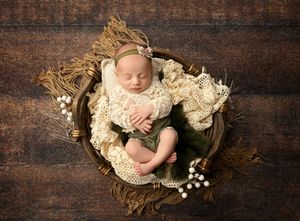 Newborn baby posed in a basket with neutral textures during a studio newborn session in New Hampshire