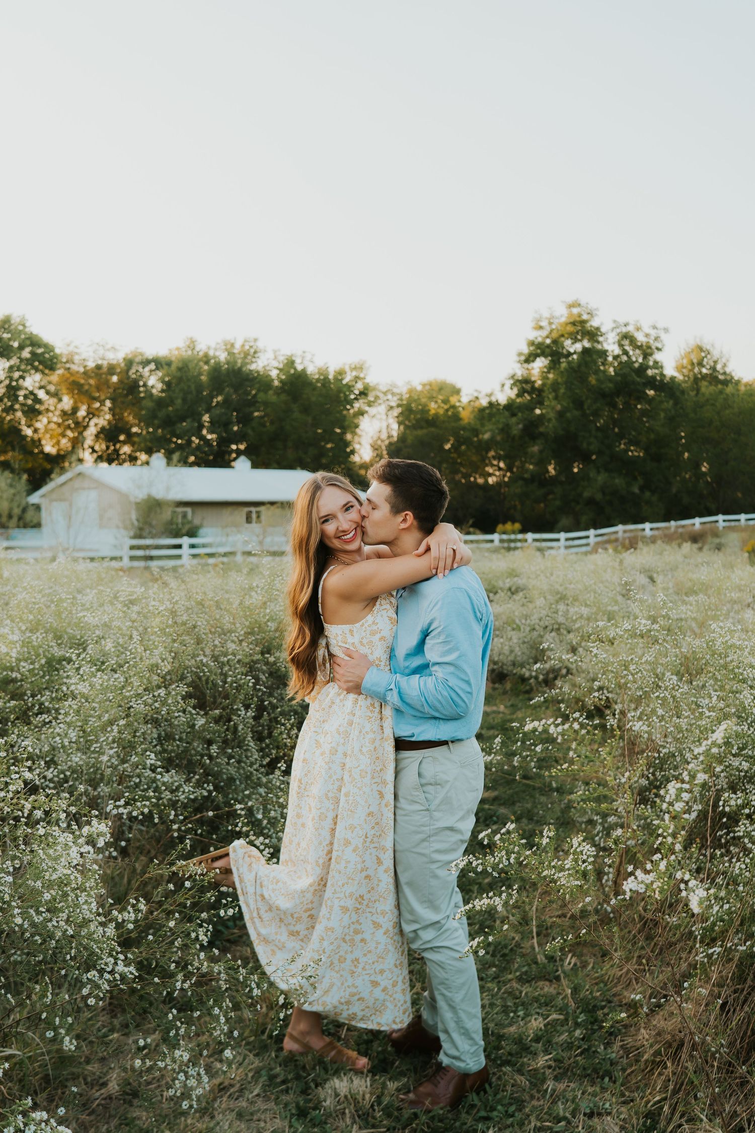 Couple embracing during an engagement photo shoot in a scenic outdoor setting.