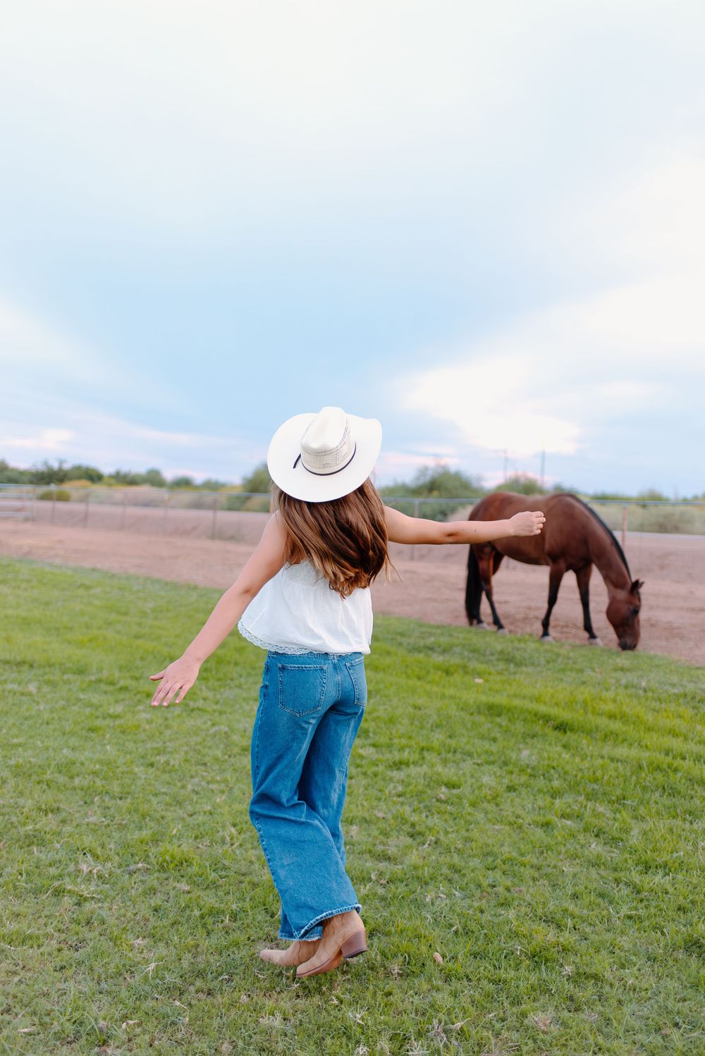 Photo of a high school senior at her senior photos in Gilbert, Arizona with her horses.