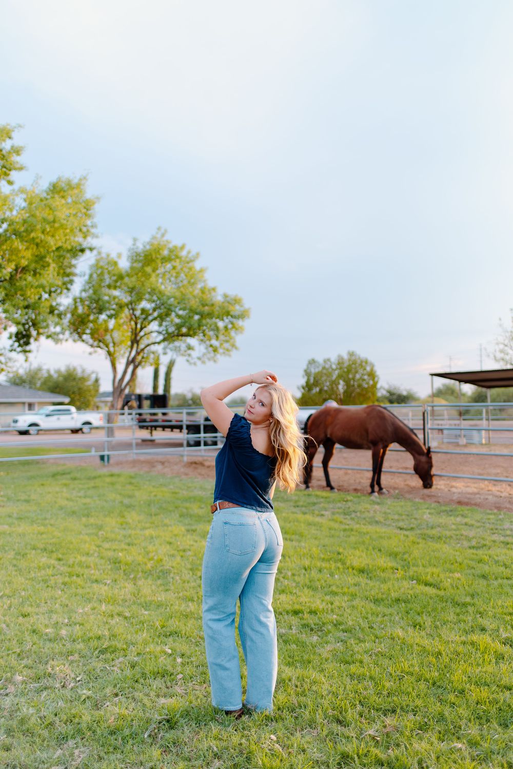 Photo of a high school senior at her senior photos in Gilbert, Arizona with her horses.