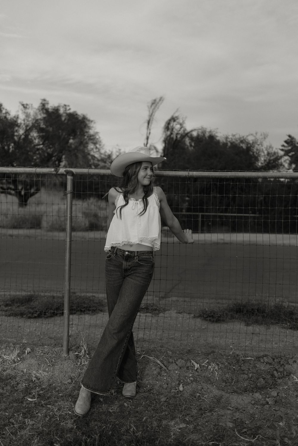 Photo of a high school senior at her senior photos in Gilbert, Arizona in a pasture setting.