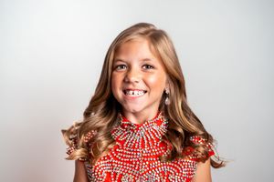 A series of four photos showing someone in a red and white gingham top expressing joyful emotions against a light background.