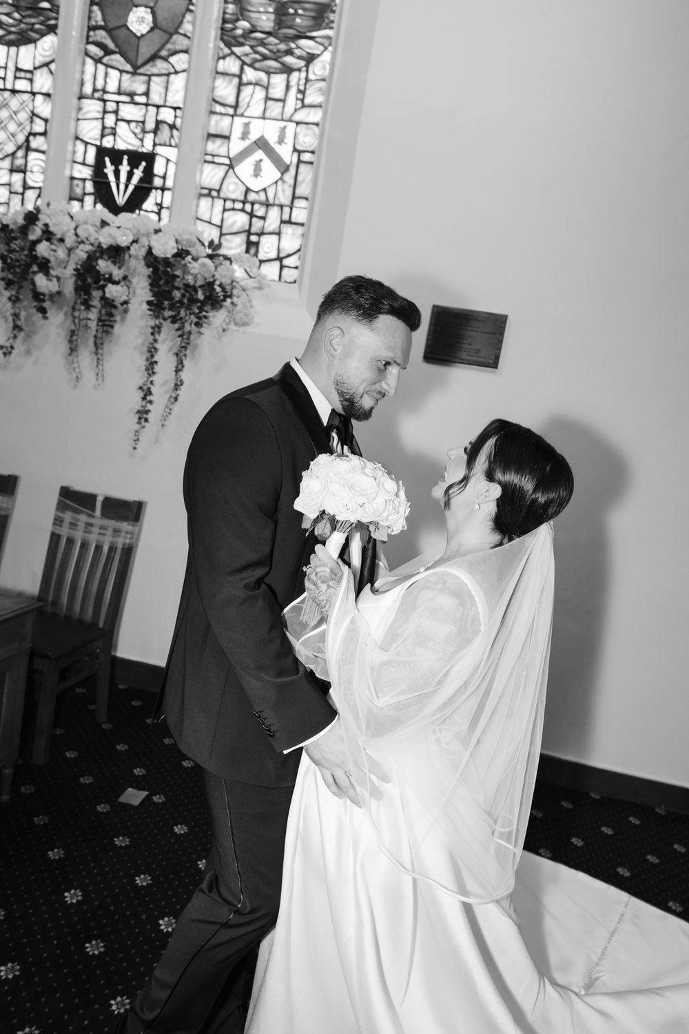 A series of black and white wedding photos showing a couple in traditional wedding attire sharing romantic moments.