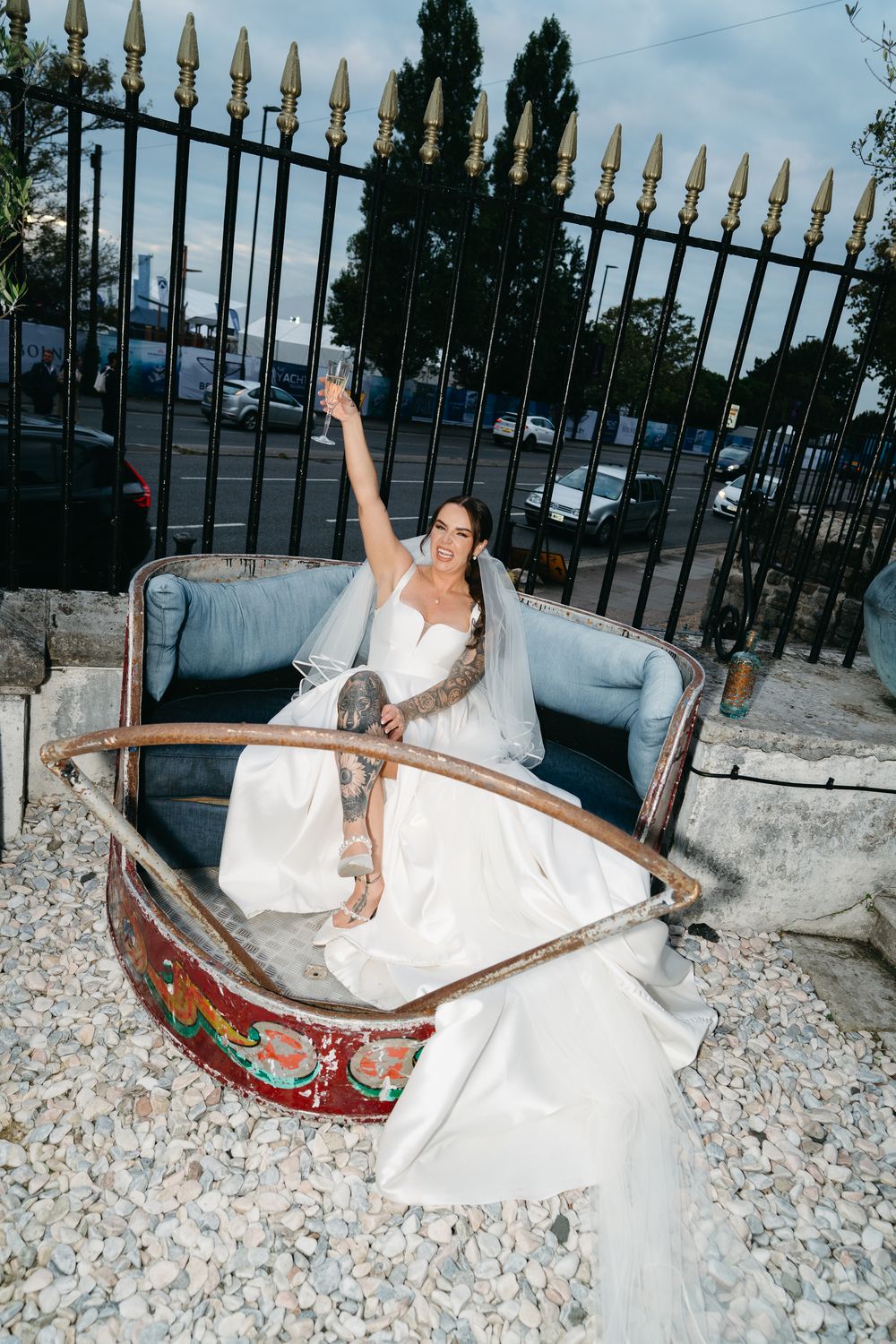 A sequence of photos showing someone in a white wedding dress posing playfully on a stone wall at dusk.