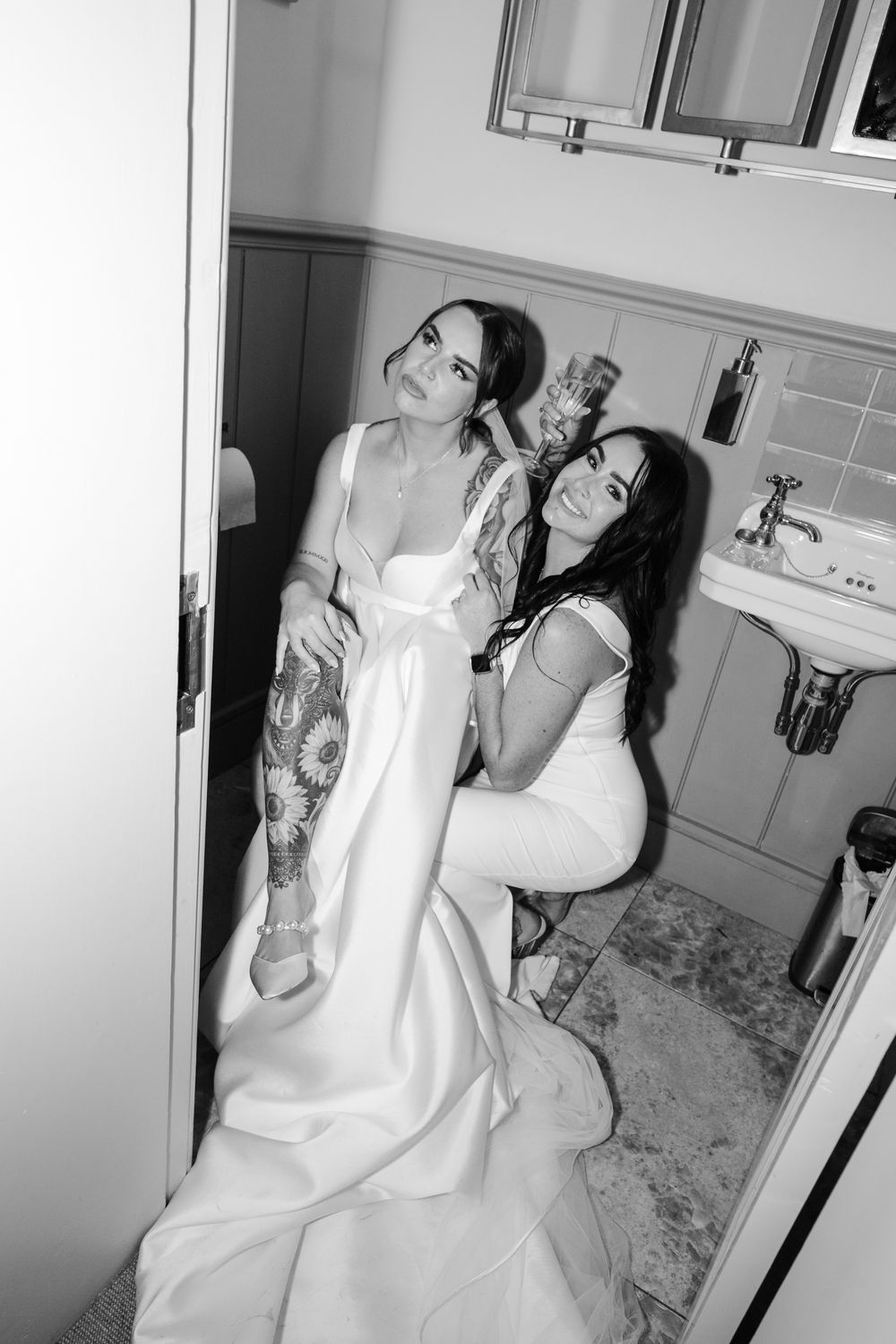 A series of four black and white photos showing a person in a white dress sitting in a bathroom.