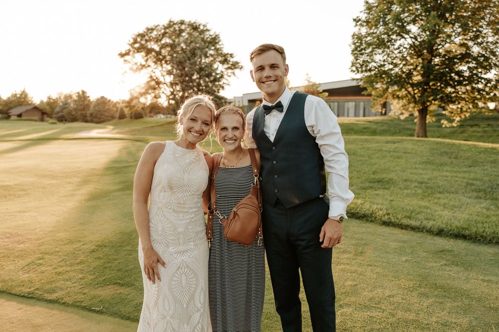 A couple poses together at sunset on a golf course during their wedding celebration.