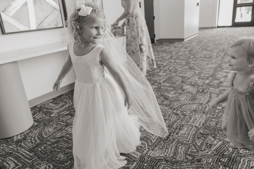 A group of young ballet dancers in white tutus practice their positions and movements during dance class.
