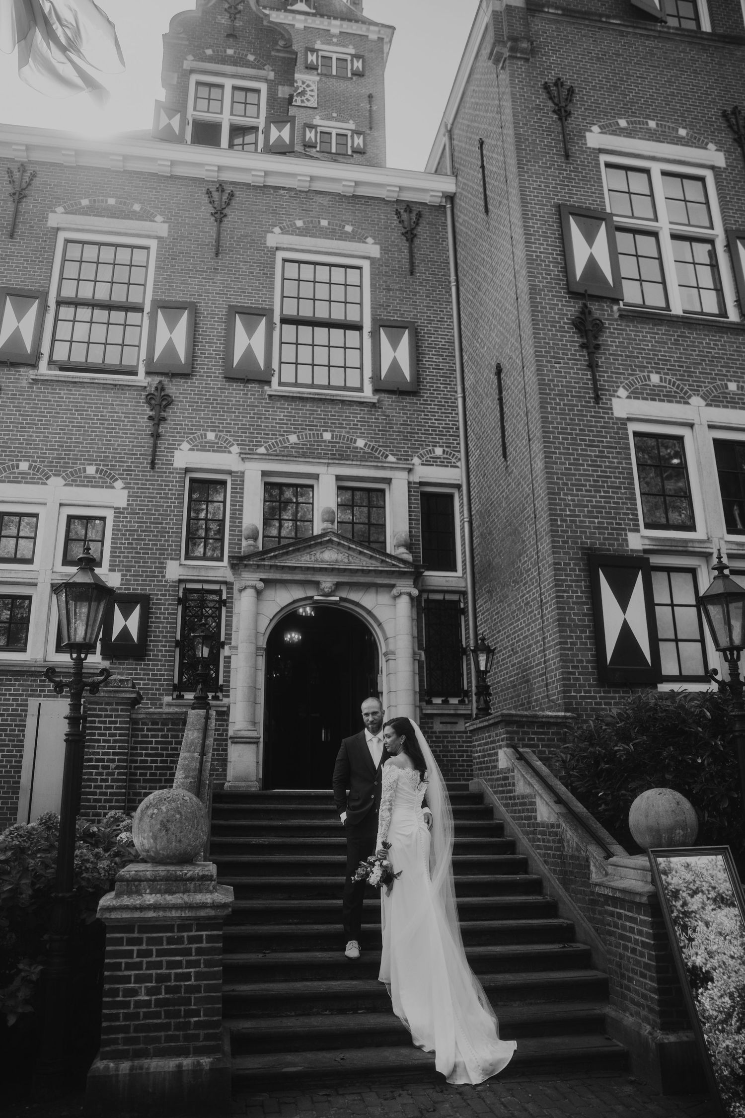 A black and white photo series showing a wedding dress flowing down brick steps of a historic building entrance.