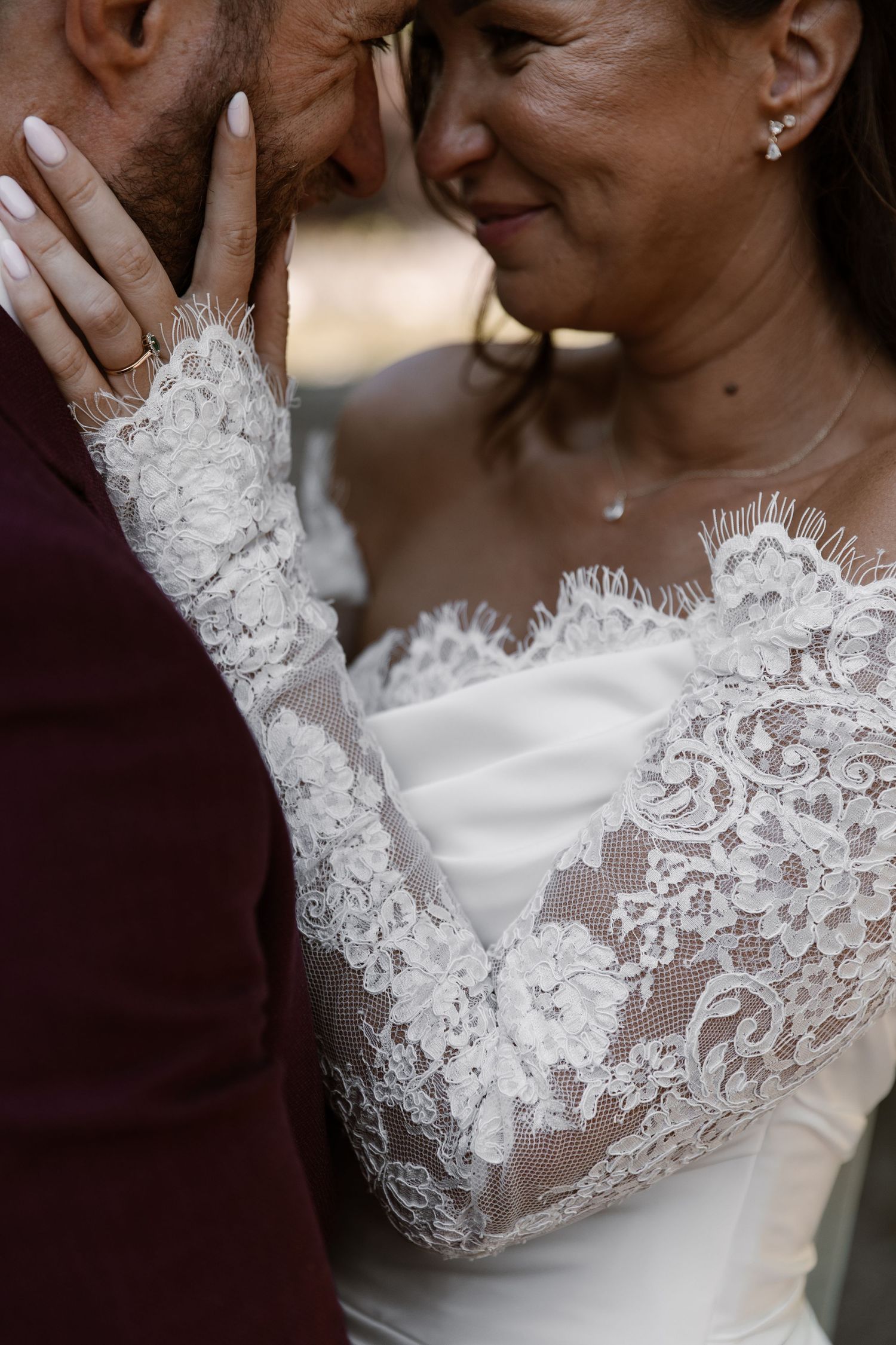 Close-up details of delicate white lace and beading on a wedding dress bodice.