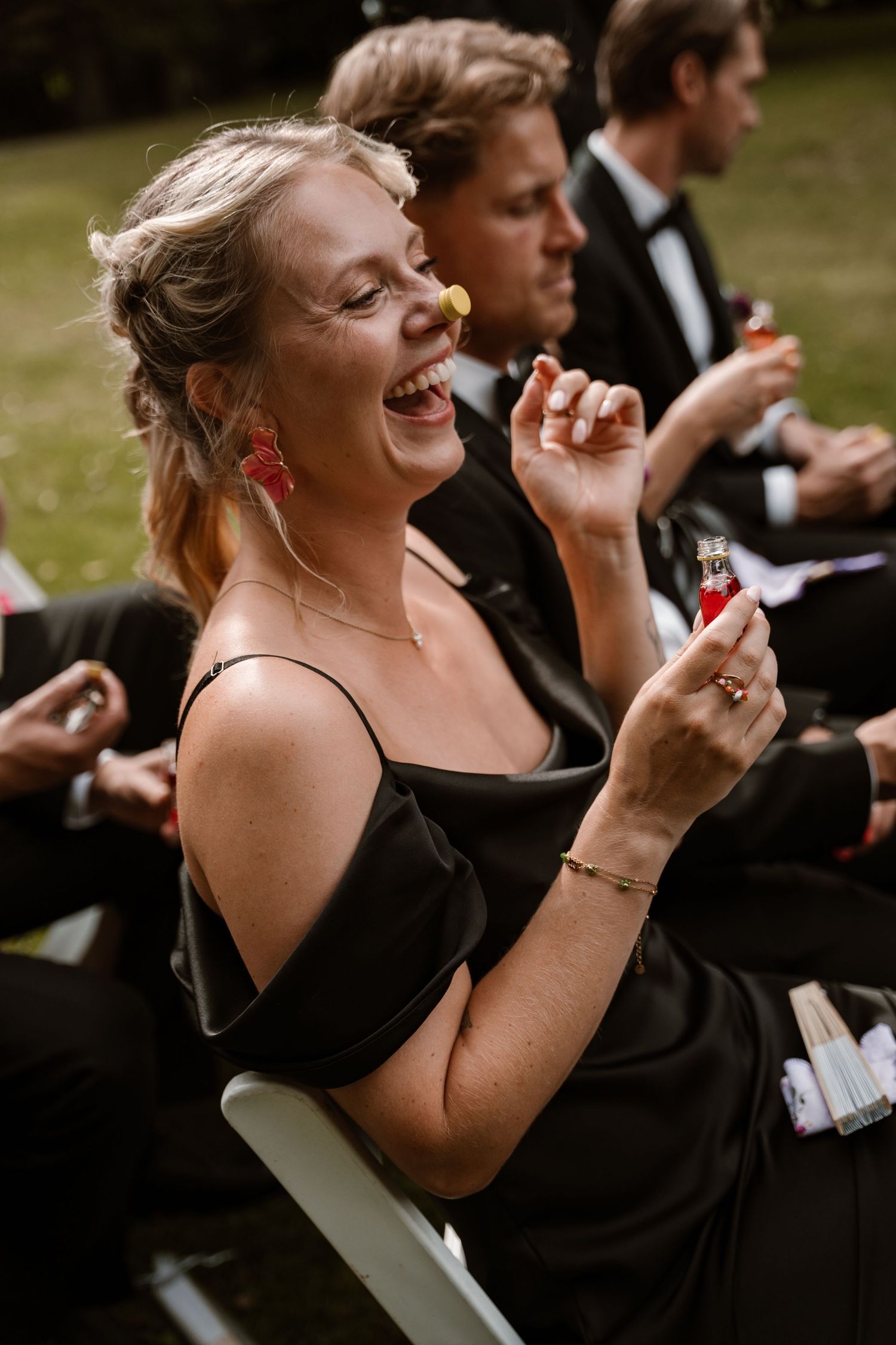A series of candid photos showing someone in a black dress laughing joyfully during a formal outdoor event.