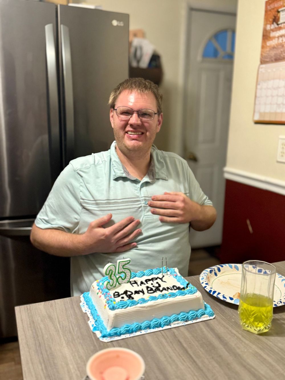A birthday celebration featuring a light blue and white decorated cake on a table.