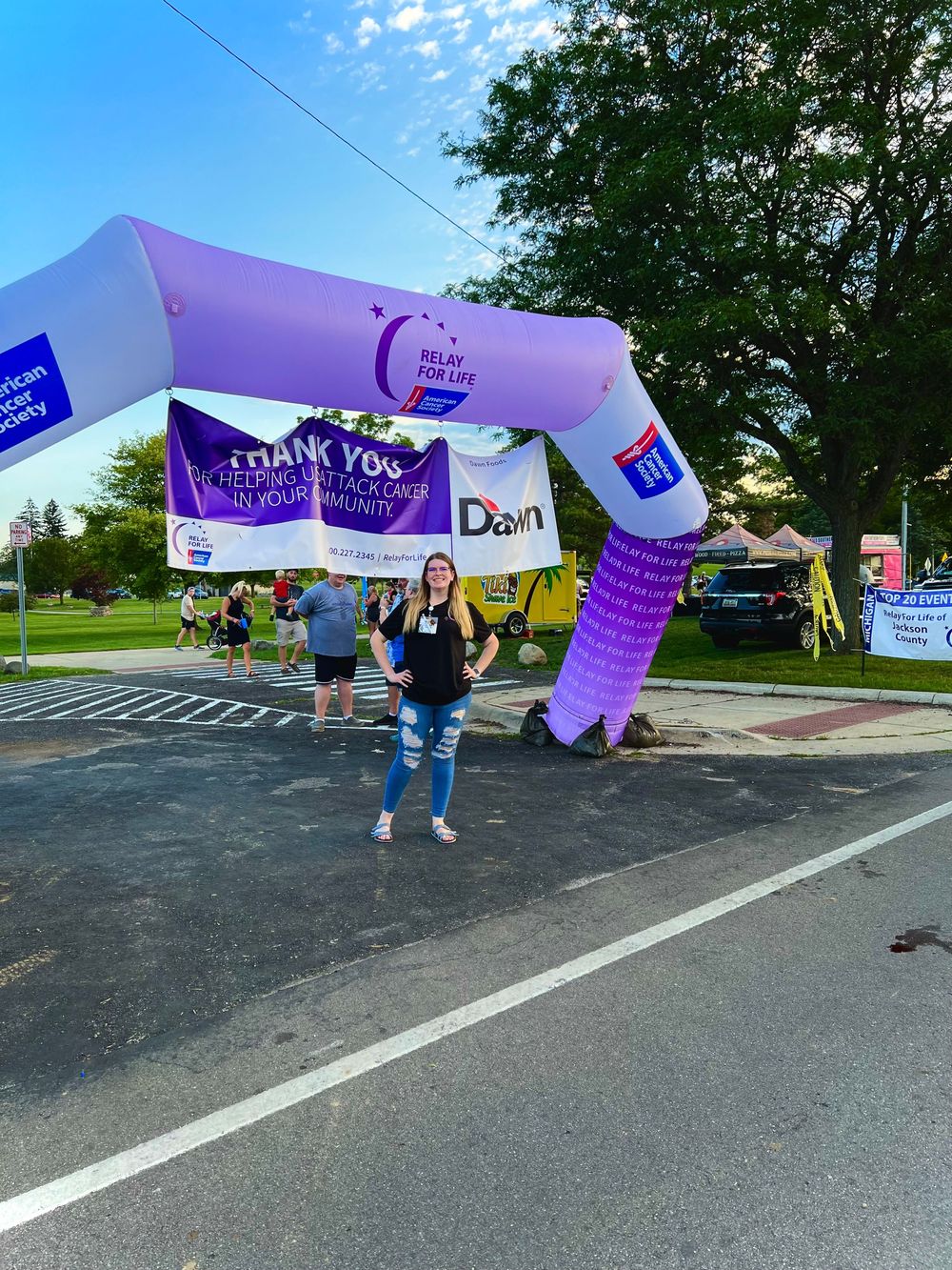 Purple banners and signs being held up at an outdoor charity event or rally.