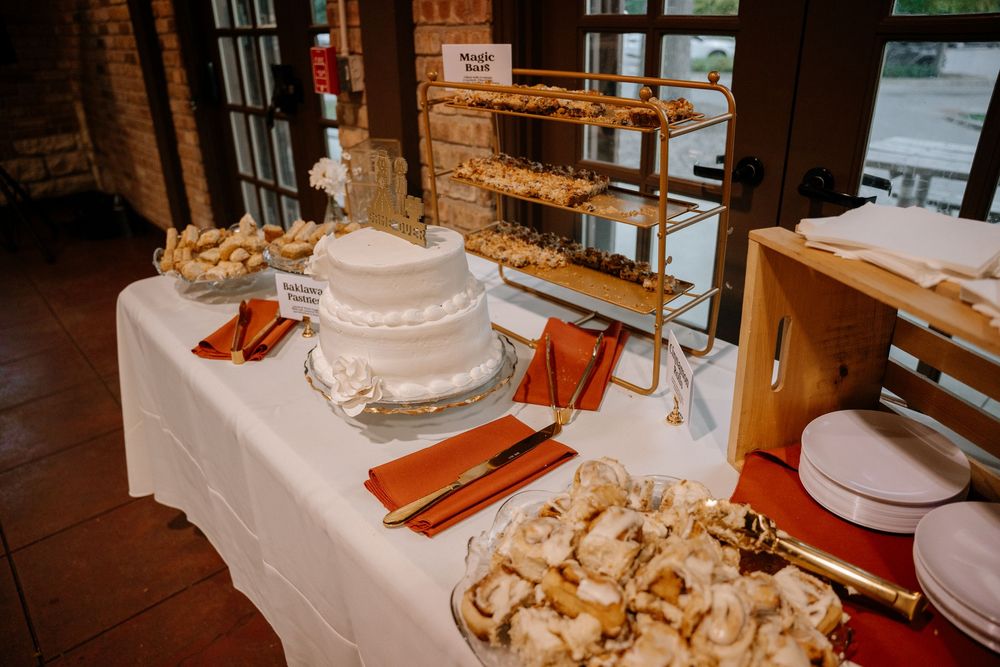 A rustic wooden table displays an assortment of fresh baked breads and pastries at a bakery counter.