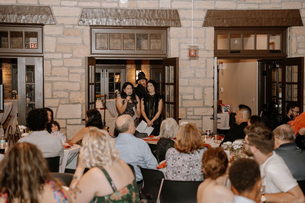 People gather in a rustic stone-walled restaurant space with warm lighting and casual dining atmosphere.