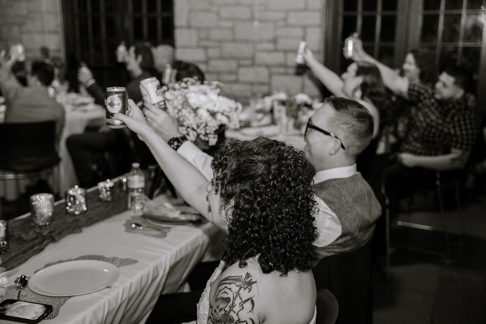 Black and white photo of people sitting at tables during a social gathering or event.