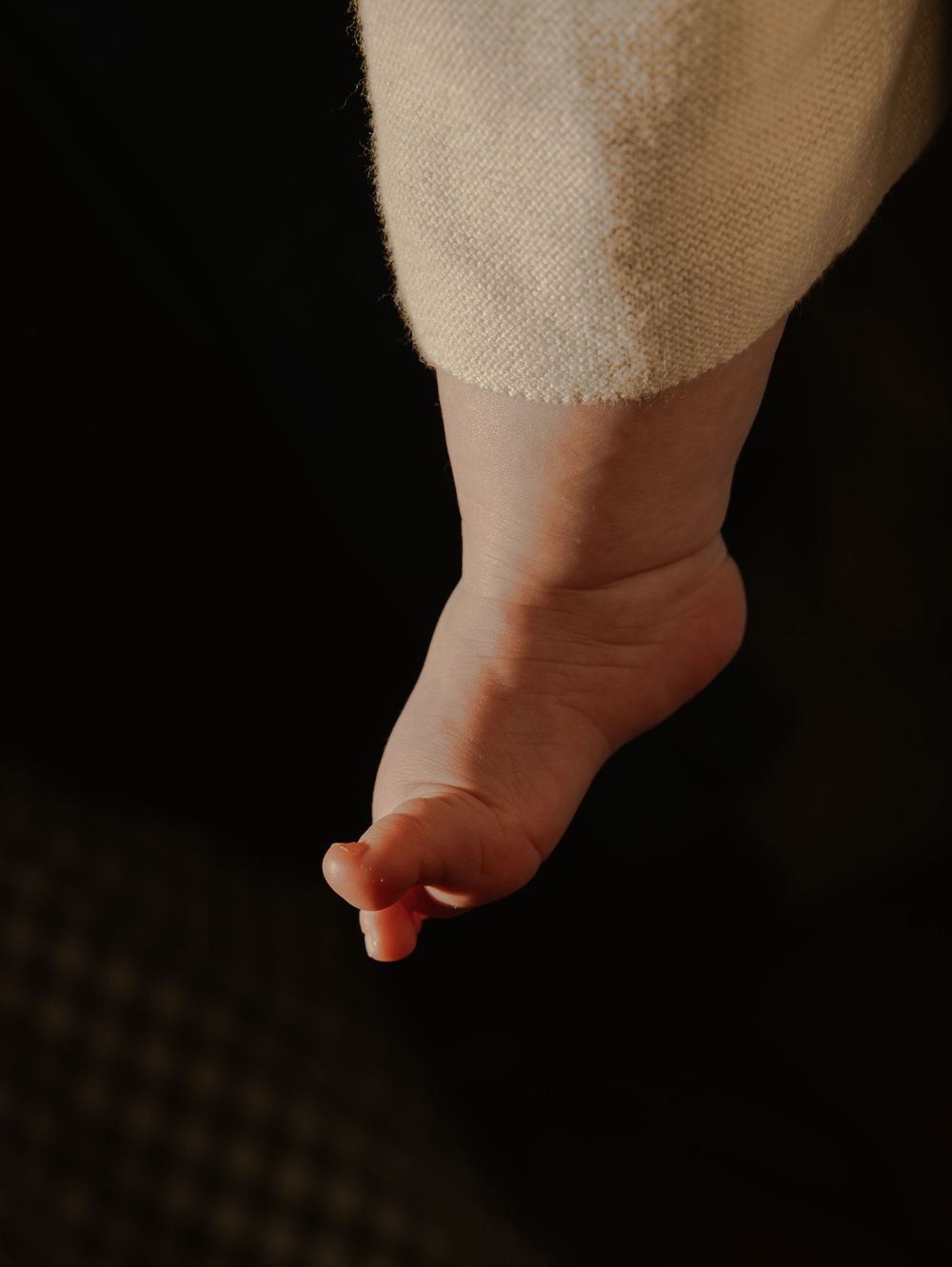A series of close-up photos showing a small baby's foot against a dark background.
