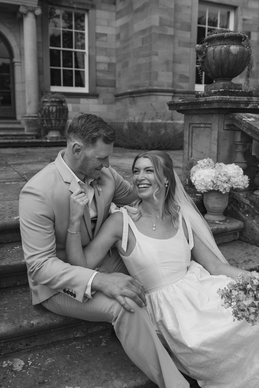 A romantic black and white photo sequence shows a couple laughing and embracing on stone steps of a historic building.