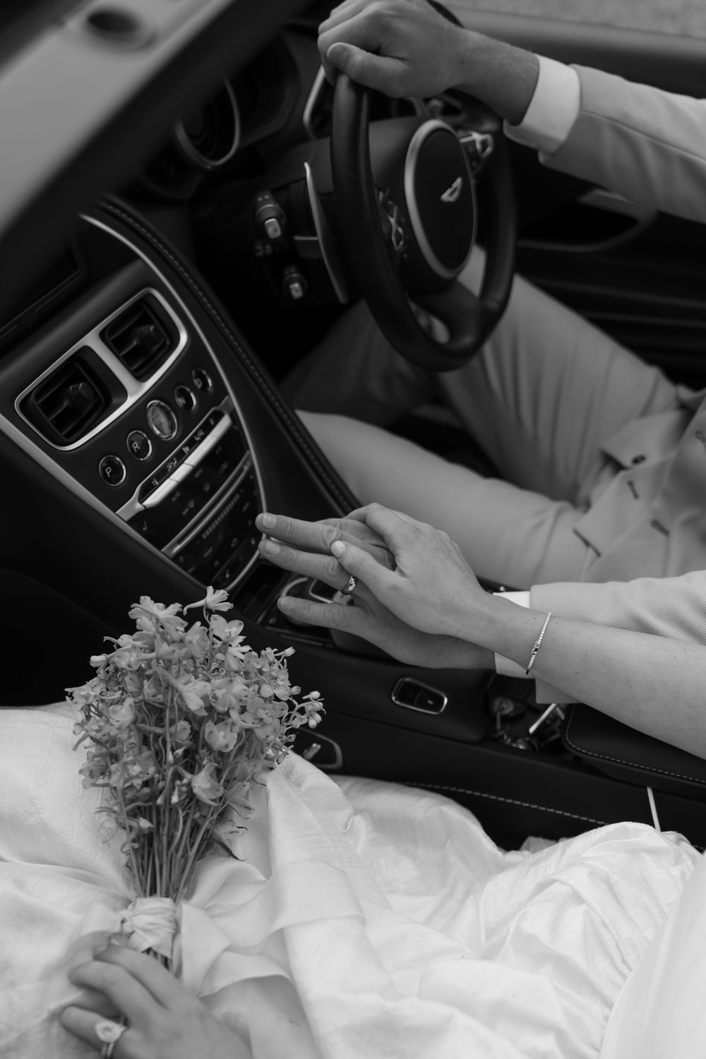 Black and white image sequence showing hands adjusting car controls and placing flowers in the passenger seat.