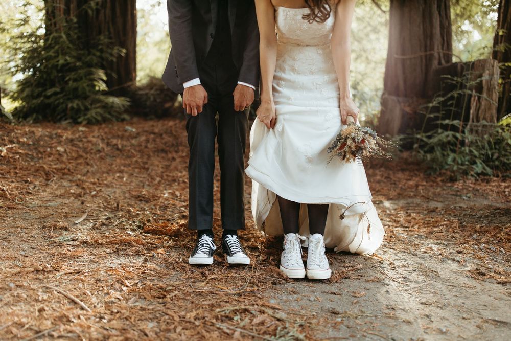 Elegant wedding detail shots focusing on white dresses and shoes against a forest backdrop.