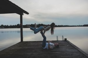 Series of dance dip poses performed by couple on lakeside dock during overcast day.