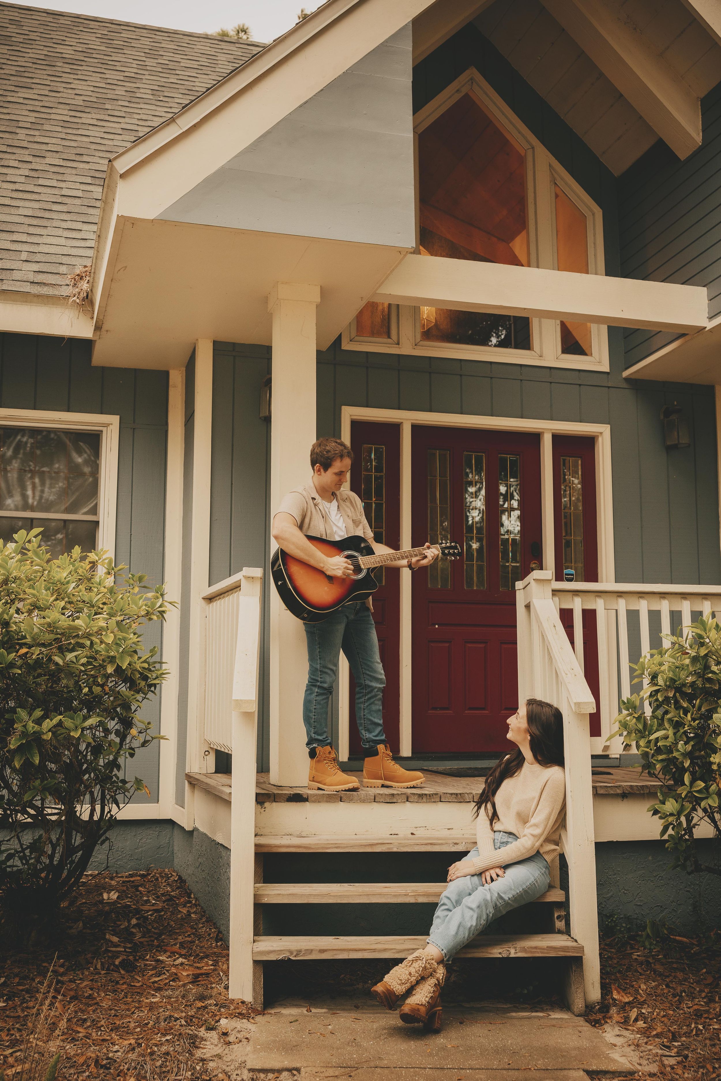 Couple relaxing on a front porch with an acoustic guitar on a sunny afternoon.