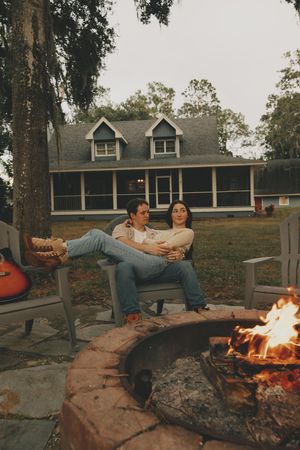 Group enjoying an evening around a campfire with Adirondack chairs.