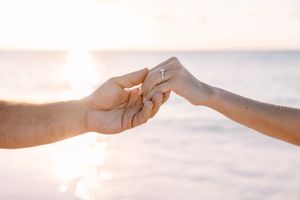 Series of hands reaching toward each other against bright sky background.