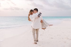 Couple playing and running together on pristine white sand beach.