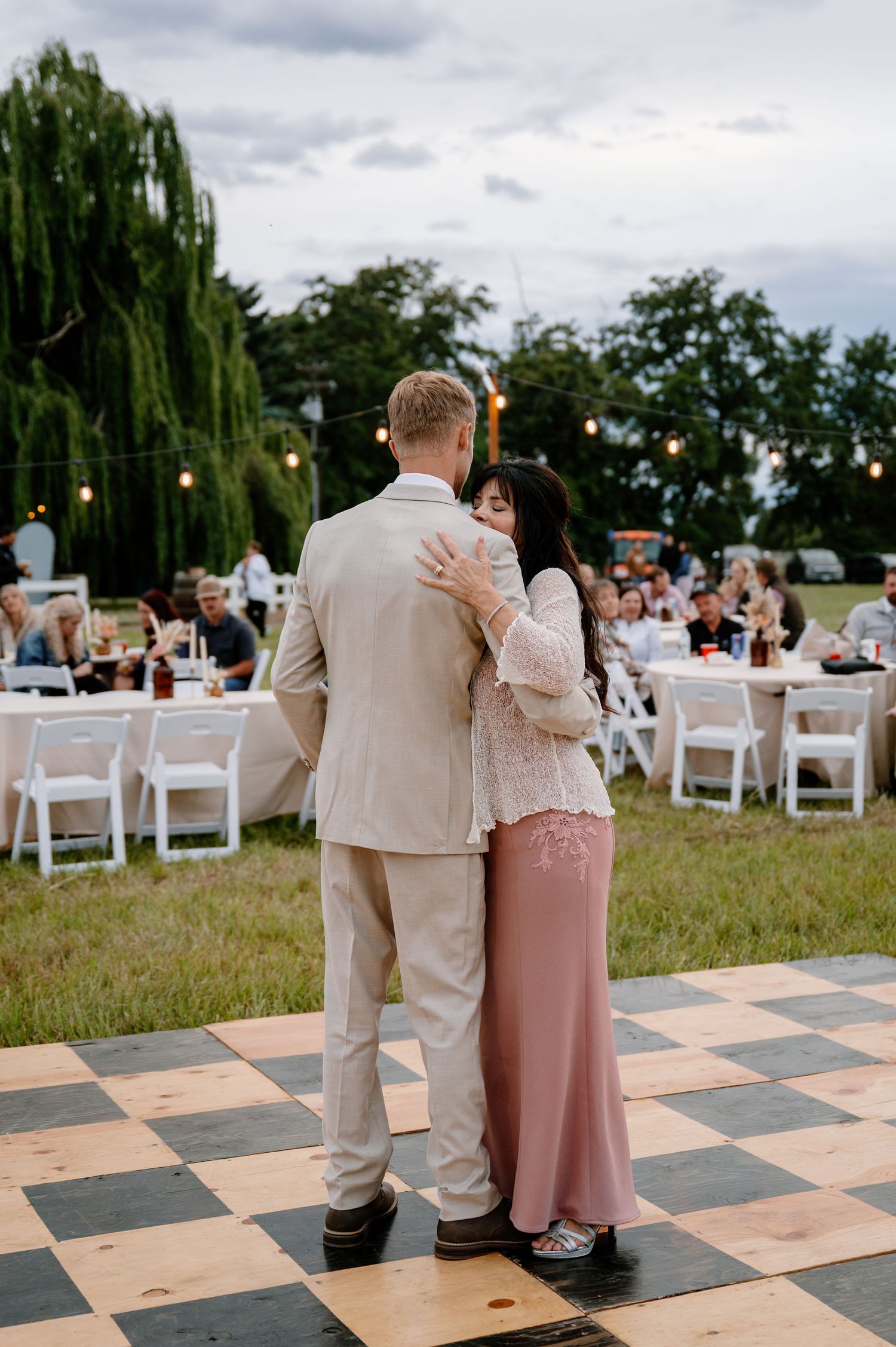 Overcast outdoor wedding reception with a checkered dance floor