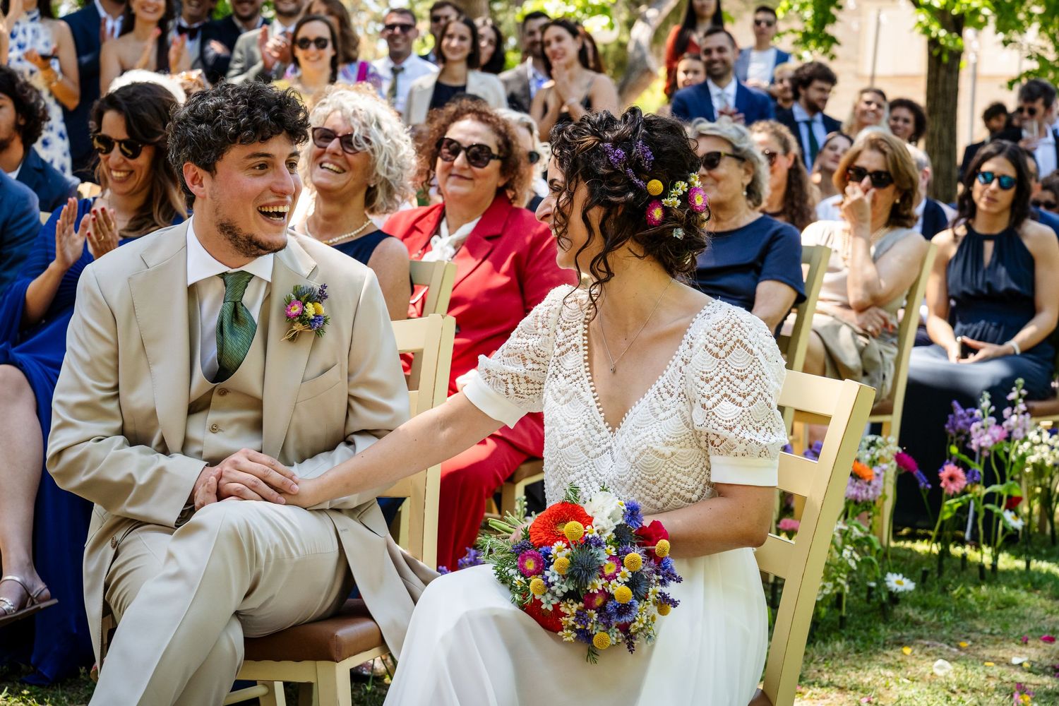 Guests celebrate and dance at an outdoor garden wedding reception surrounded by birch trees and string lights.