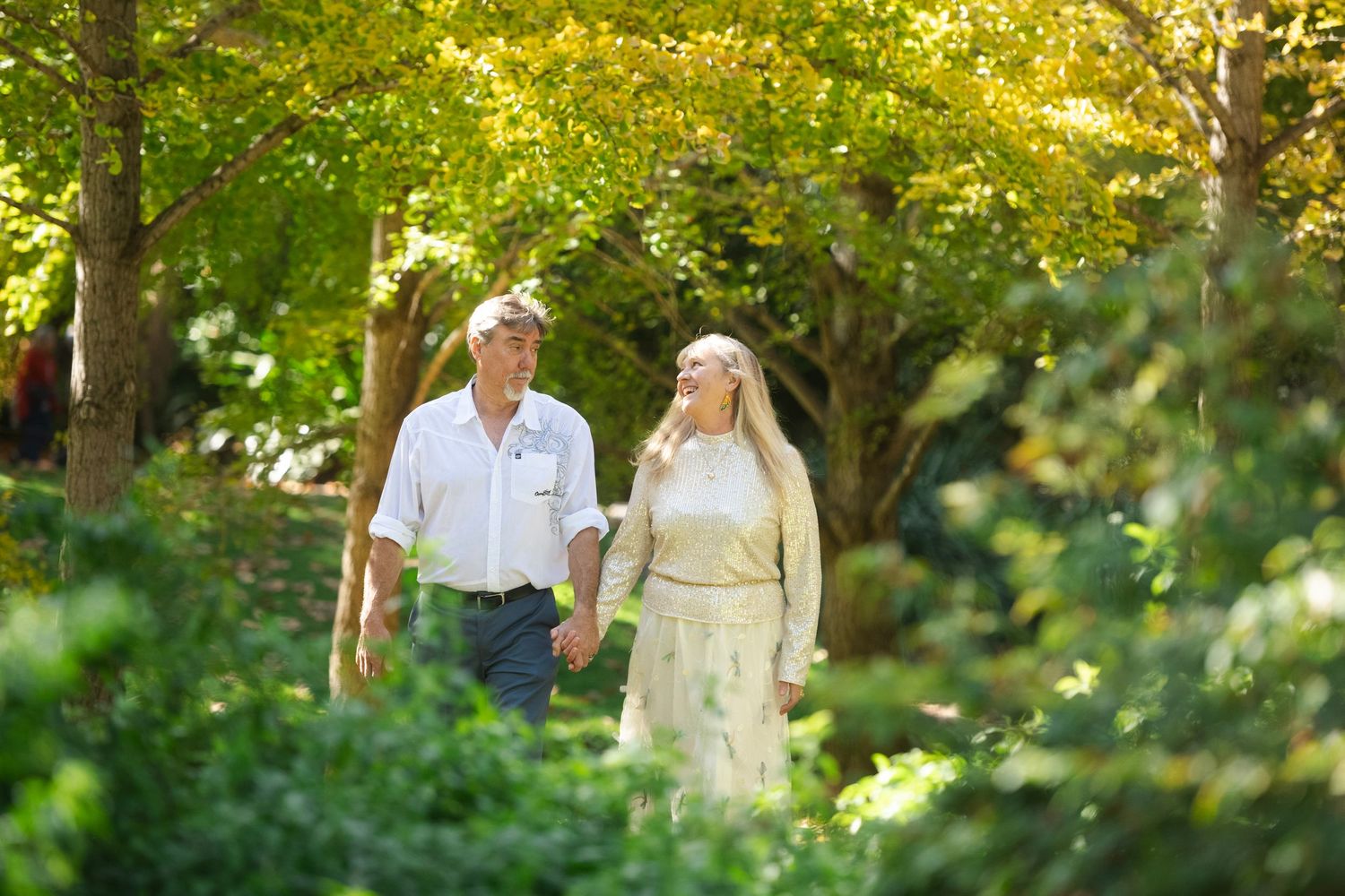 Natural light portrait session in lush green garden setting.