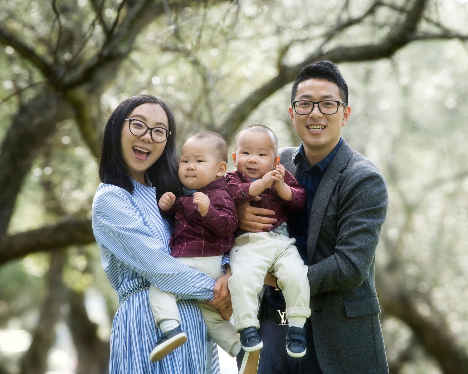 Family portrait series outdoors under trees with soft natural lighting.