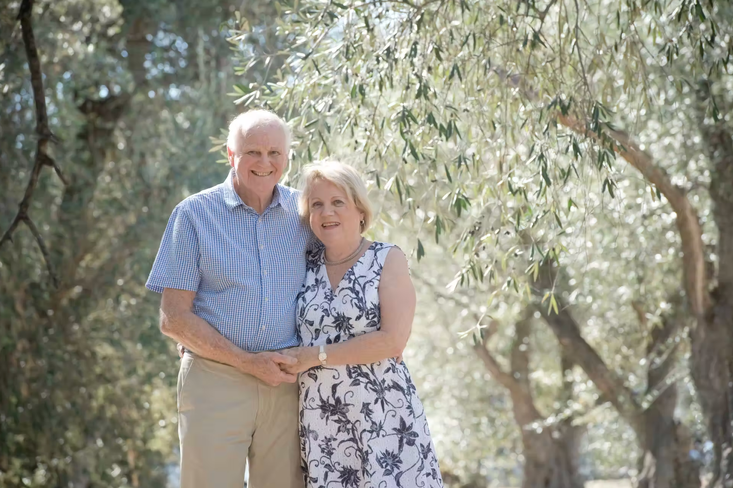 Romantic outdoor family portraits captured under flowering trees with dreamy lighting.
