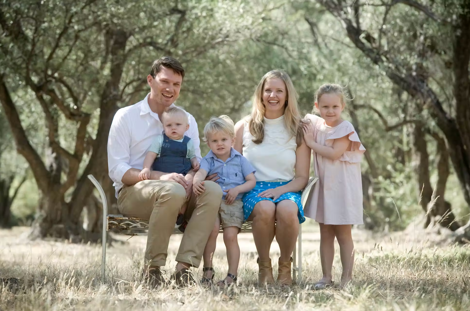 Candid family moments captured outdoors in a natural setting with soft lighting.