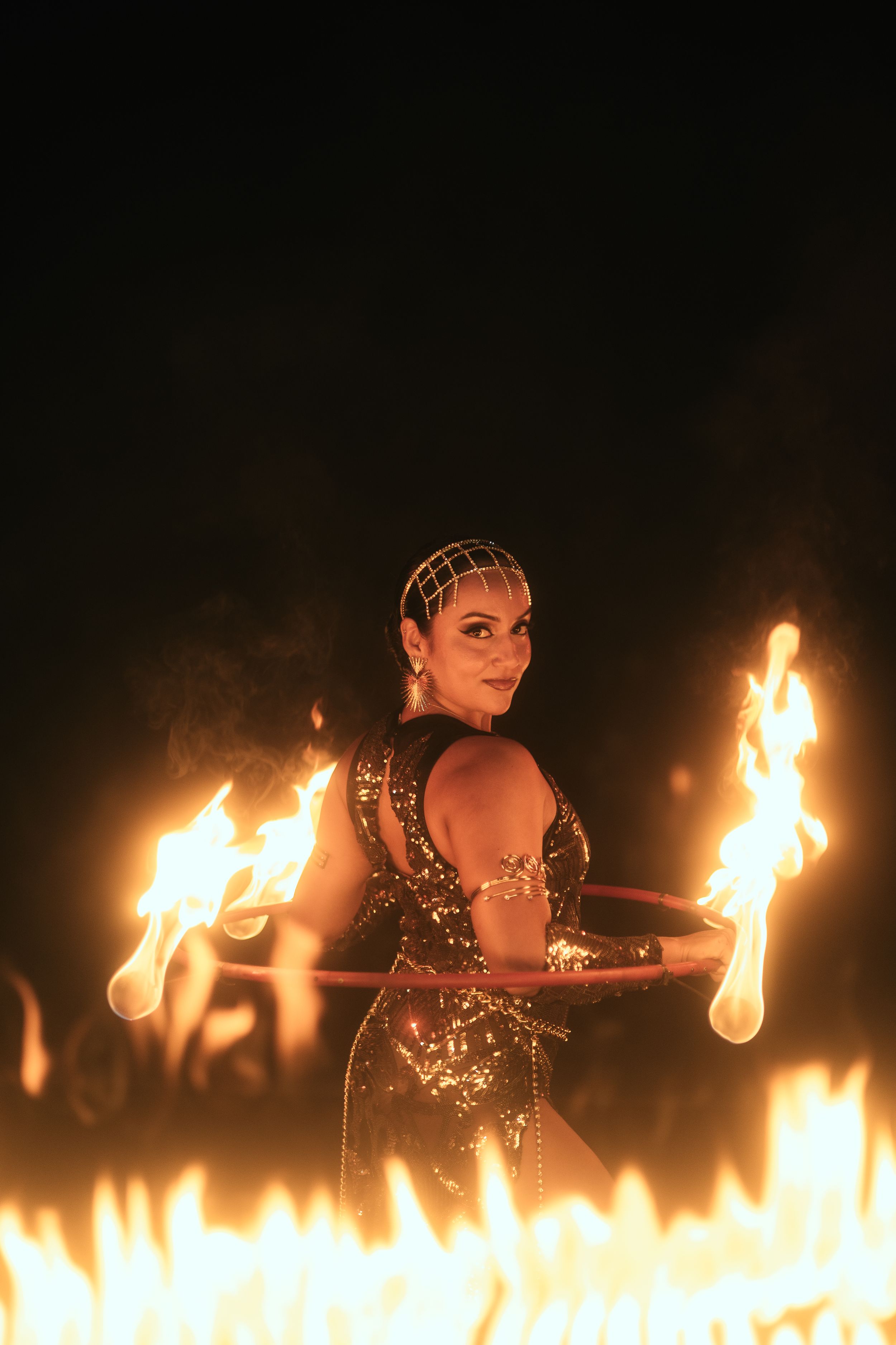 Miami fire performer captured by Mannyportraits. Center-stage flame display with strong presence and dramatic spotlight contrast.