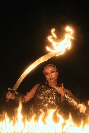 Fire performer photographed by Mannyportraits in Miami. Dramatic sweeping flame motion with intense stage atmosphere and warm fire glow.