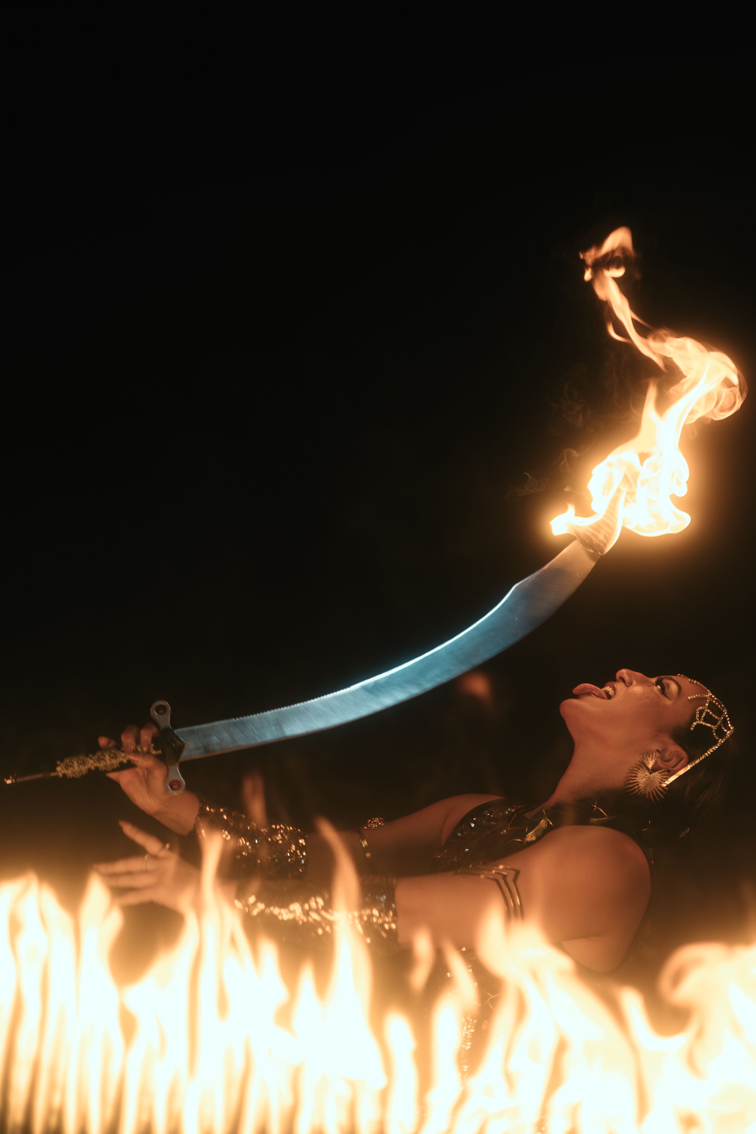 West Palm Beach fire artist photographed by Mannyportraits. Expressive movement, flowing posture, and theatrical fire stage lighting.