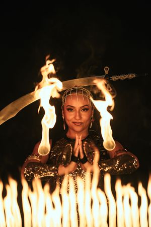 Cinematic fire dancer captured by Mannyportraits in Fort Lauderdale. Performer lifting twin flame torches with confident, controlled movemen